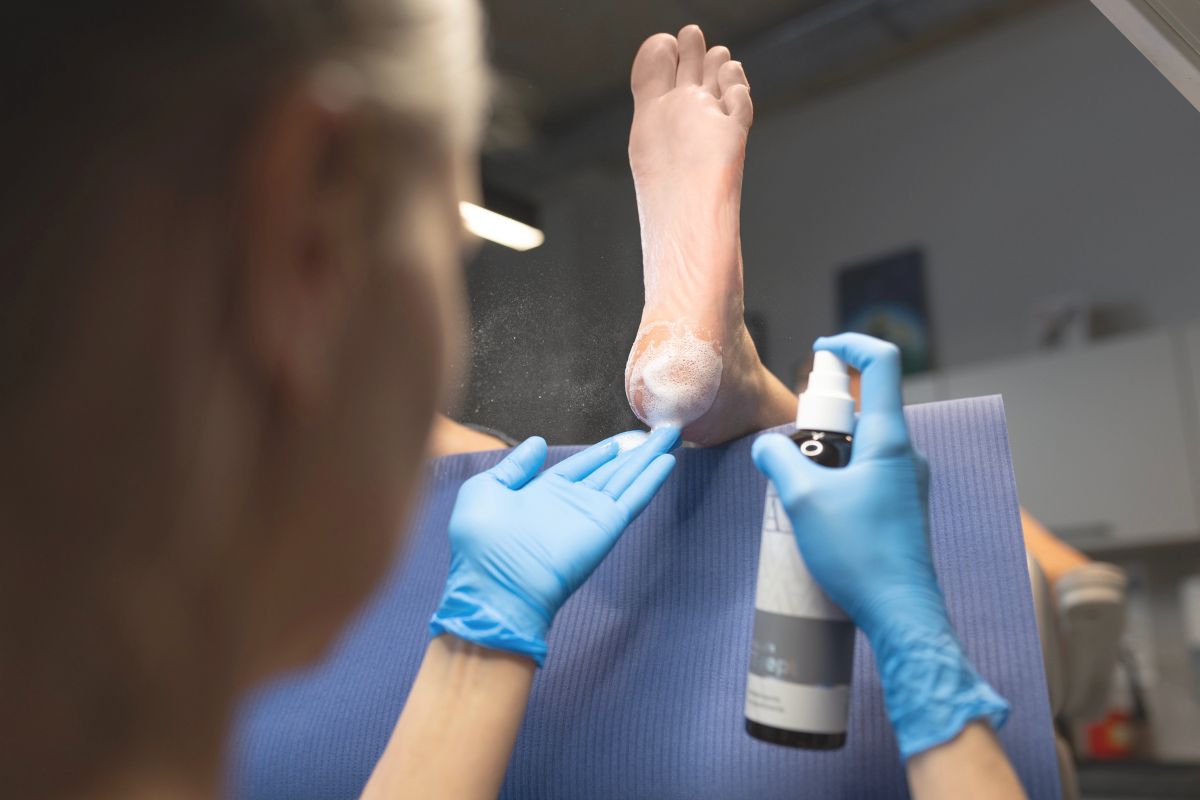 podolog dezynfekuje stopę w gabinecie
